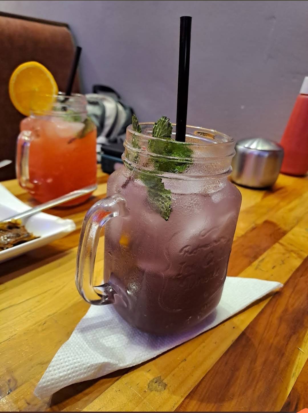 Frosted mason jars of house mocktails garnished with mint