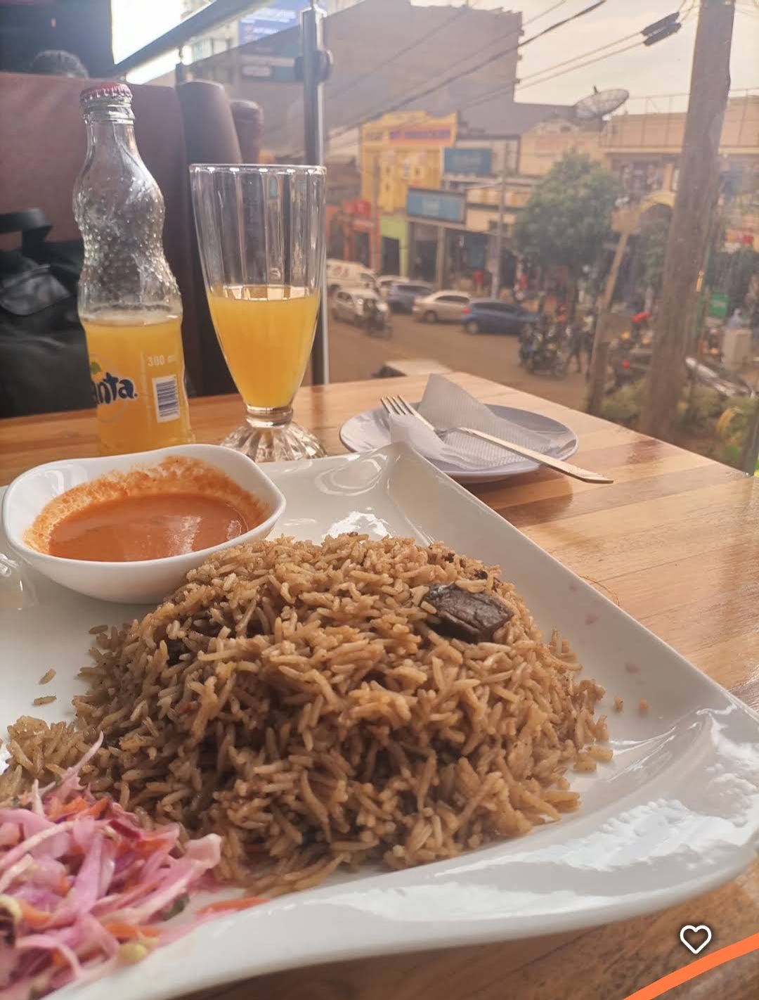 A plate of beef pilau with kachumbari by the window at Andy's